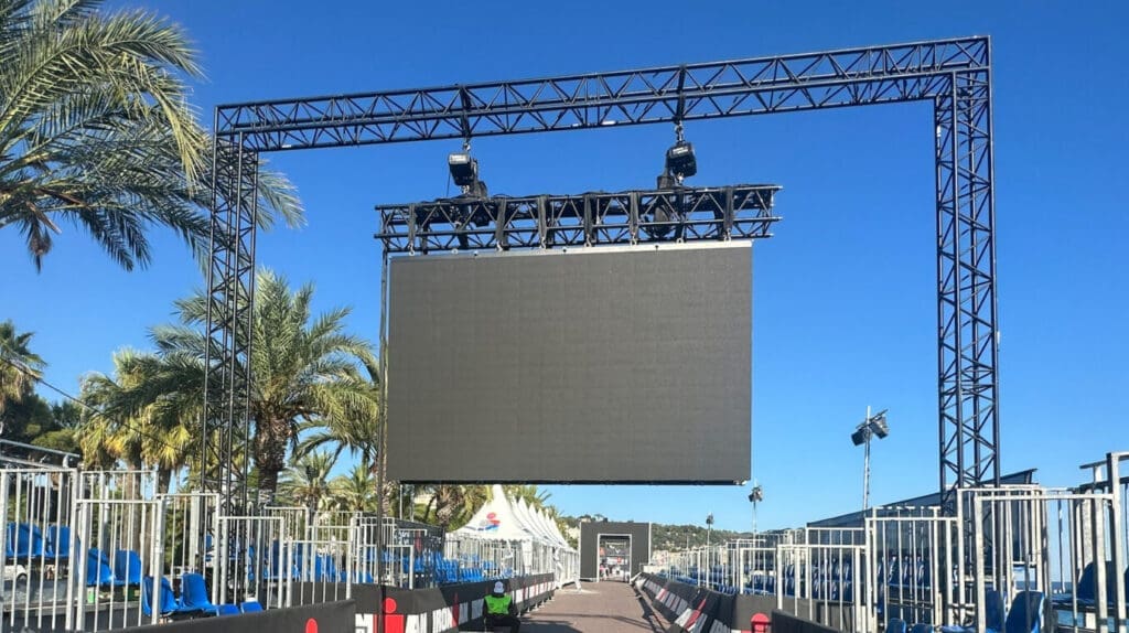 An LED screen being flown on a truss arch over the finish line chute at the IRONMAN World Championship.